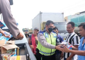Anggota polisi saat memberikan snack kepada warga (dok. Humas Polda Jambi)